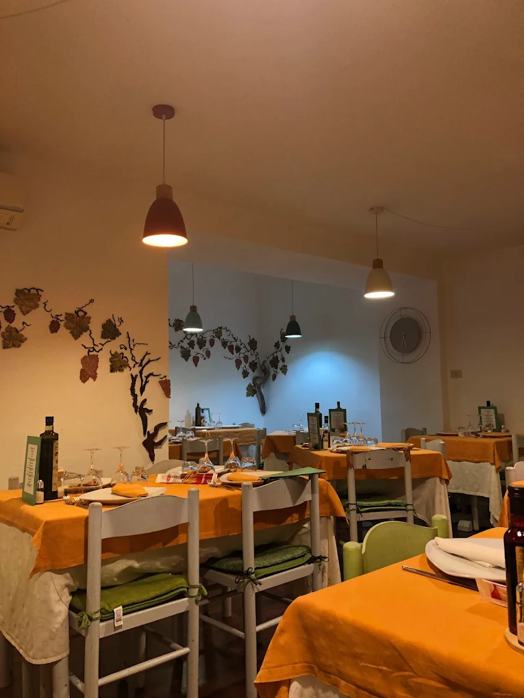 Sala interna della Trattoria Al Corsica, tovaglie color ambra e lampade a sospensione